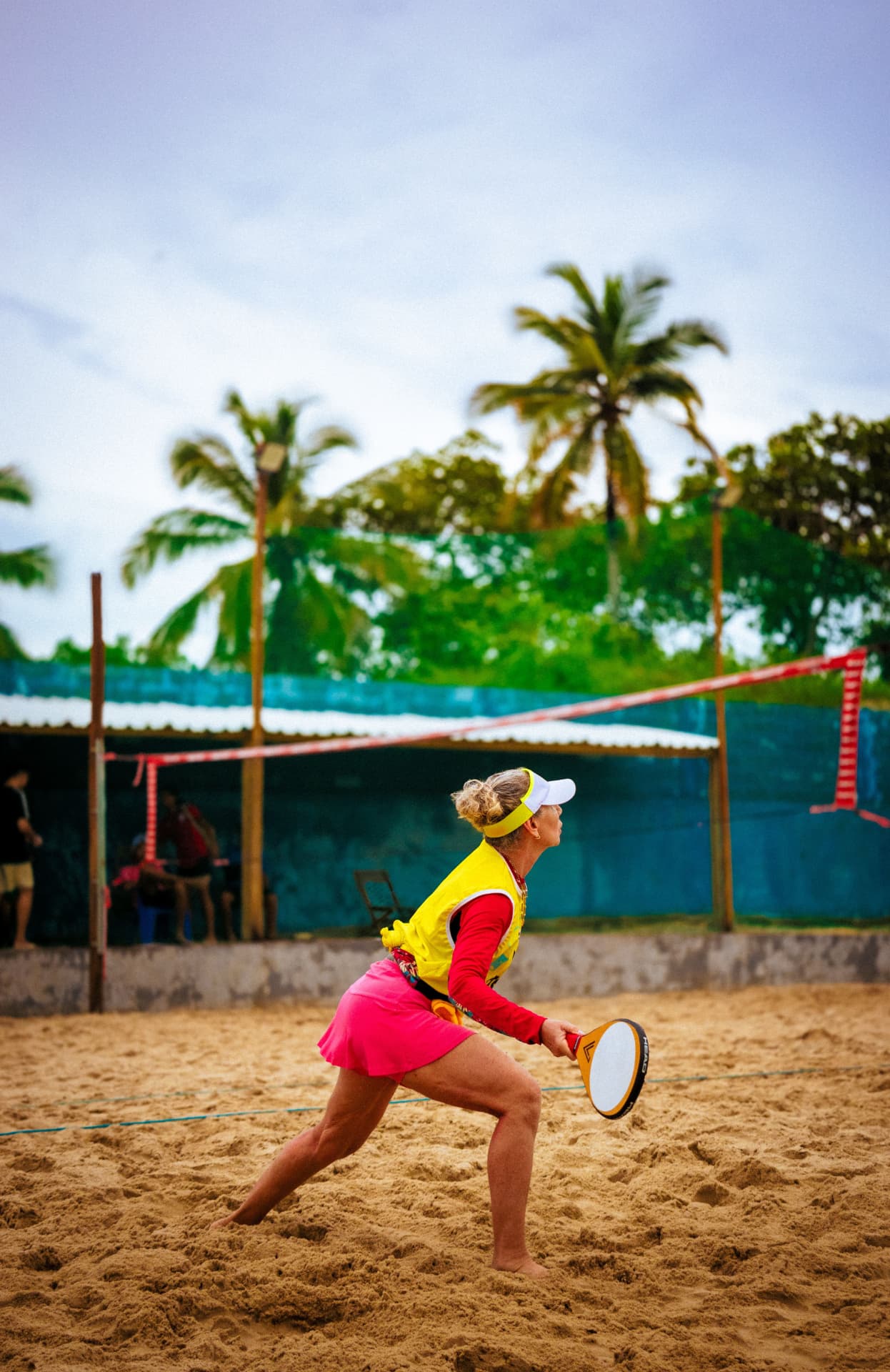 Beach tennis player in action on a tropical sand court