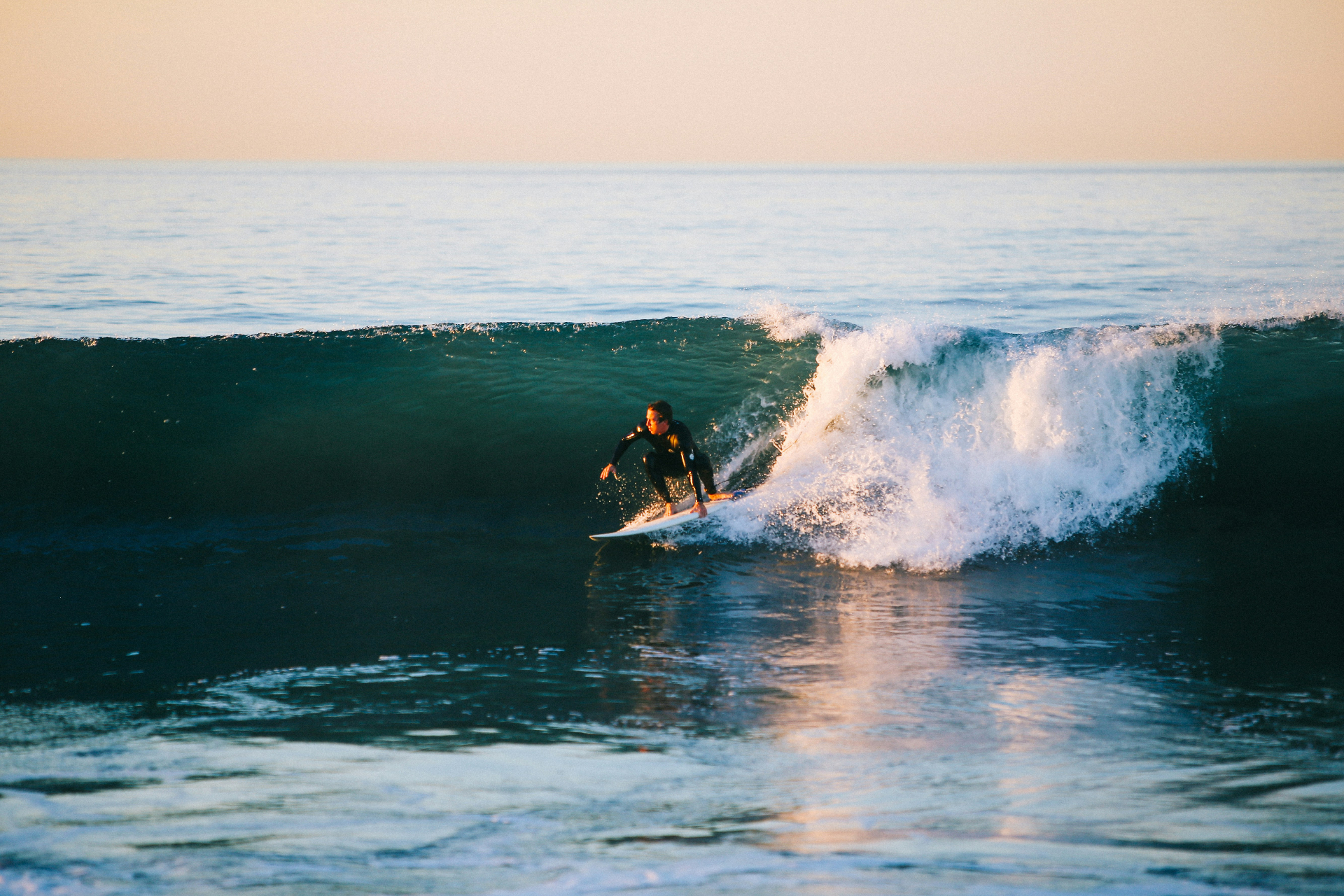 Surfer carving a wave at golden hour