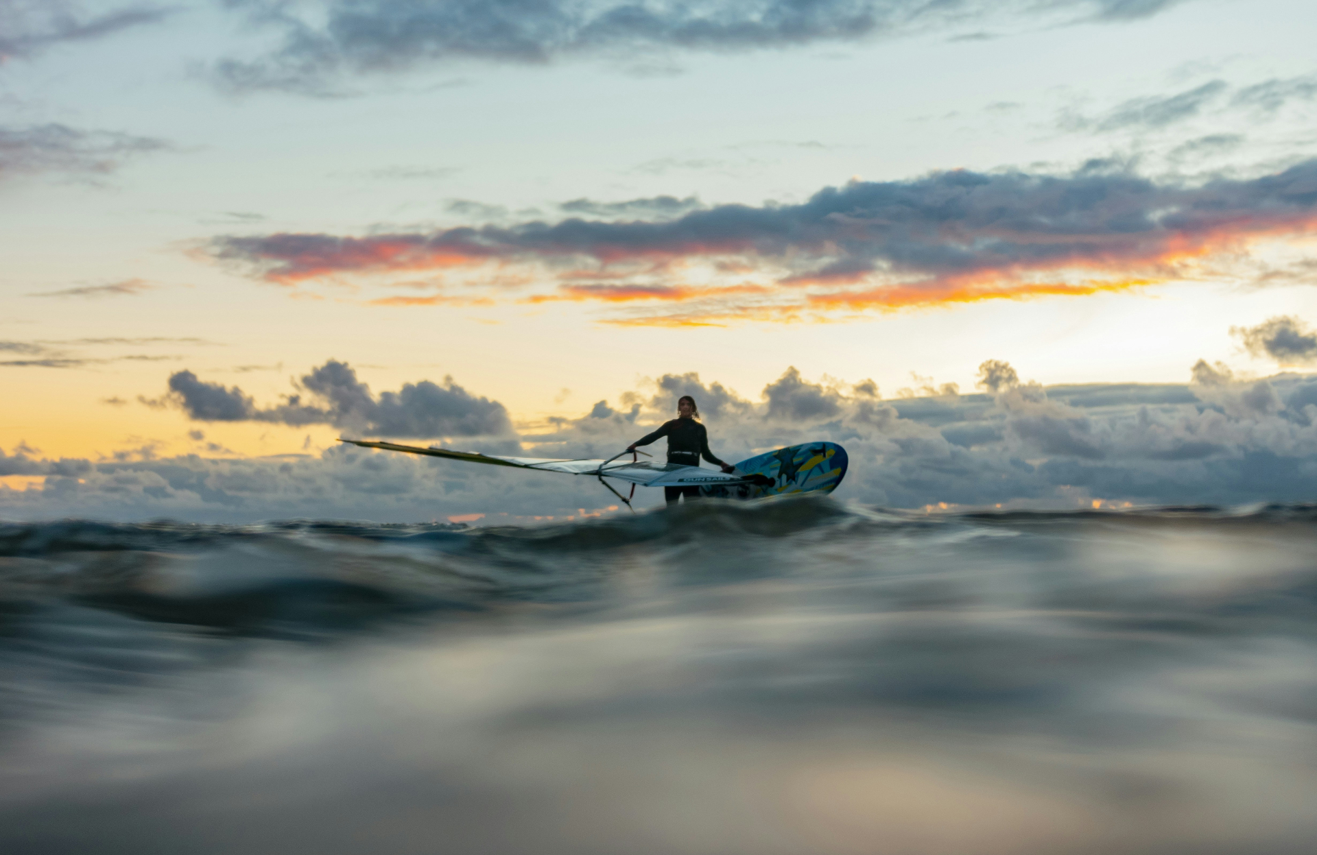Windsurfer on the ocean at sunset